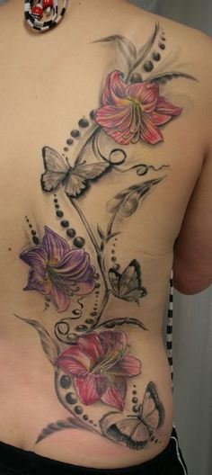 a woman's back with flowers and butterflies on it