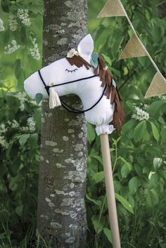 a white horse head mounted to a tree