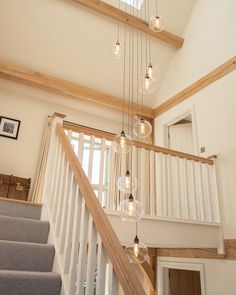 the light fixture is hanging from the ceiling above the stairs in this modern style home