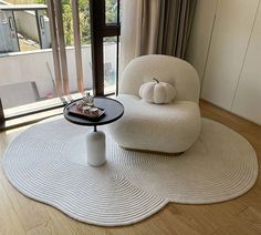 a living room with a white rug and chair in it, next to a window