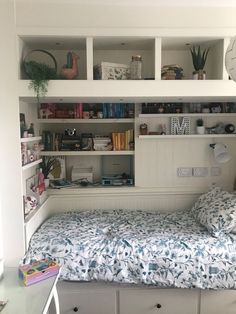 a bedroom with a bed, desk and shelves