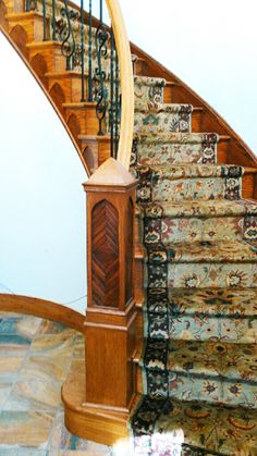 an ornate wooden staircase with handrails and carpet