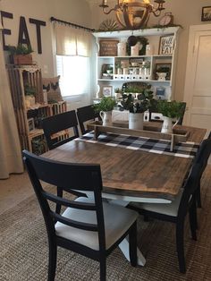 the dining room table is set with black chairs and white dishes on top of it