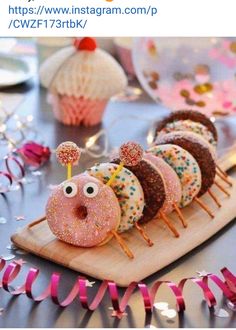 there are donuts with sprinkles on them sitting on a wooden board