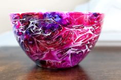 a colorful glass bowl sitting on top of a wooden table