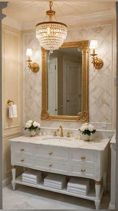 a bathroom vanity with two sinks and a large mirror above it, all decorated in gold