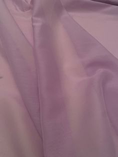 a close up view of the fabric on a pink bed sheet set with white sheets and pillows