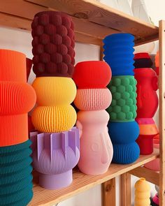 many colorful vases are on shelves in a room