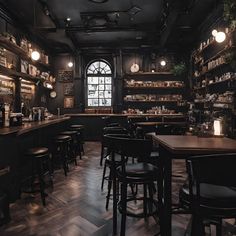 a dimly lit bar with lots of stools and tables in front of the counter