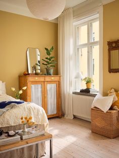 a bedroom with yellow walls and wooden floors