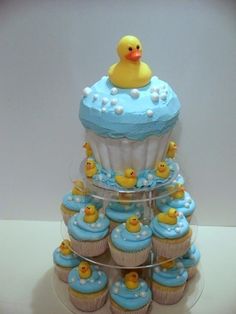 cupcakes with blue frosting and rubber ducks are stacked on top of each other