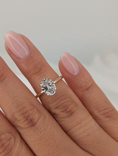 a woman's hand with a ring on her finger and a diamond in the middle