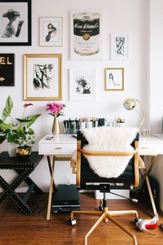 a white desk with lots of pictures on the wall above it and a chair in front of it