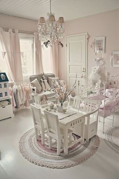 an instagram photo of a pink and white living room with chandelier hanging from the ceiling