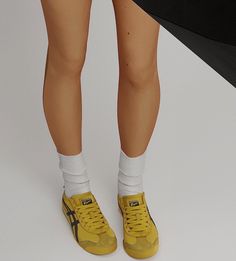 the legs and feet of a woman wearing yellow tennis shoes