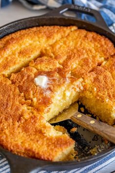 a skillet with some food inside of it and a wooden spoon in the pan