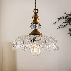 a glass light fixture hanging from a ceiling