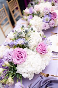 the table is set with purple and white flowers