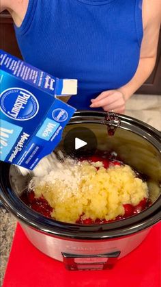 a woman pouring milk into a crock pot filled with food