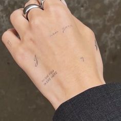 a person's hand with two rings on it and writing on the ring finger