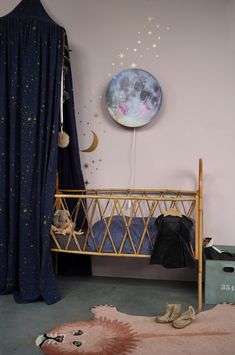 a child's bedroom with pink walls and gold stars on the ceiling, along with a moon shaped balloon