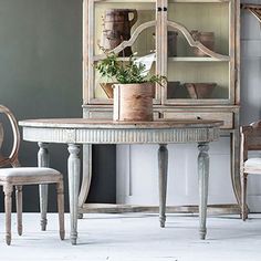 a dining room table with chairs and a hutch in the corner next to it