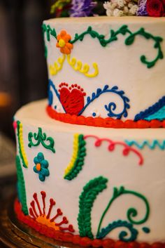 two tiered cake decorated with multi colored flowers