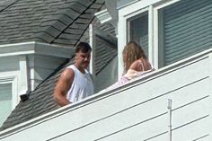 two people standing on the roof of a house