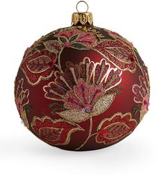 a red christmas ornament with gold trimmings and a bird on it