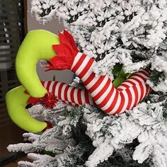 a christmas tree decorated with elf's legs and stockings