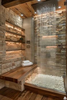 a bathroom with stone walls and wooden flooring, along with a glass shower stall