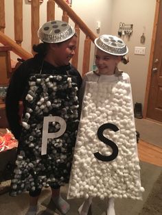 two children dressed up in costumes with letters on them