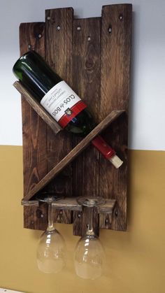 two wine glasses and a bottle in a wooden holder