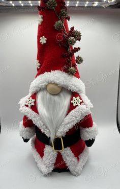 a santa clause figurine sitting on top of a white table next to a christmas tree