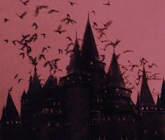 a flock of birds flying in front of a castle with red and black sky behind it