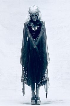 black and white photograph of a woman wearing a cape