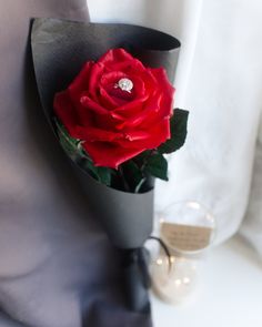 a boutonniere with a red rose in it