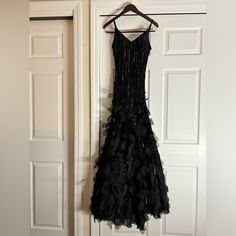 a black dress hanging on a white door