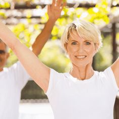 an older woman with her hands up in the air and two younger men behind her