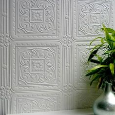 a potted plant sitting on top of a white shelf next to a wallpaper