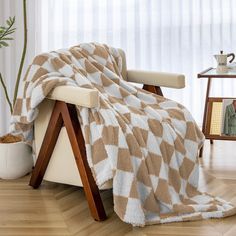 a chair with a blanket on top of it in front of a potted plant