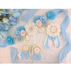 blue and white flowers are arranged in a circle on the ground with ribbons around them