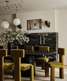 a dining room with yellow chairs and a black table surrounded by white flowers in vases