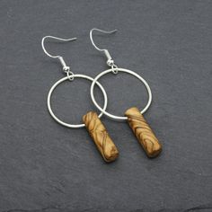 Handmade solid olive wood earrings with a satin Argentium silver ring and silver ear wire hooks. The olive wood used to craft these earrings comes directly from olive cultivation in the Holy Land and is coated with olive oil only to maintain its natural warmth. Thanks to its beautiful streaks and shades, the olive wood gives to each earrings pair a unique and personal aspect. The soldered Argentium silver ring has a satin finish and adds a touch of elegant shine thanks to its white gold-like col Wood Jewellery Handmade, Wood Jewelry Diy, Wooden Wedding Bands, Stainless Steel Wedding Ring, Silver Bead Earrings, Wooden Jewellery, Nugget Necklace, The Holy Land, Wood Project