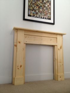 an empty room with a painting on the wall and a fire place in front of it