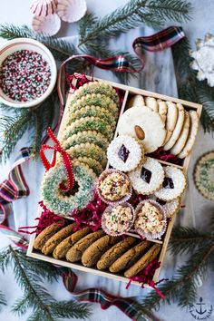 a box filled with cookies and crackers on top of a table next to christmas decorations