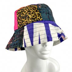 a white mannequin head wearing a multicolored hat with leopard print on it