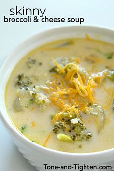 a white bowl filled with broccoli and cheese soup on top of a table