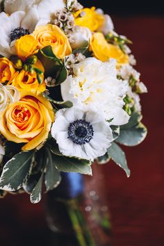 a bouquet of yellow and white flowers in a vase