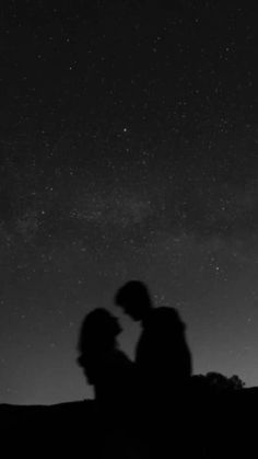 two people are standing under the stars in the night sky with their backs to each other